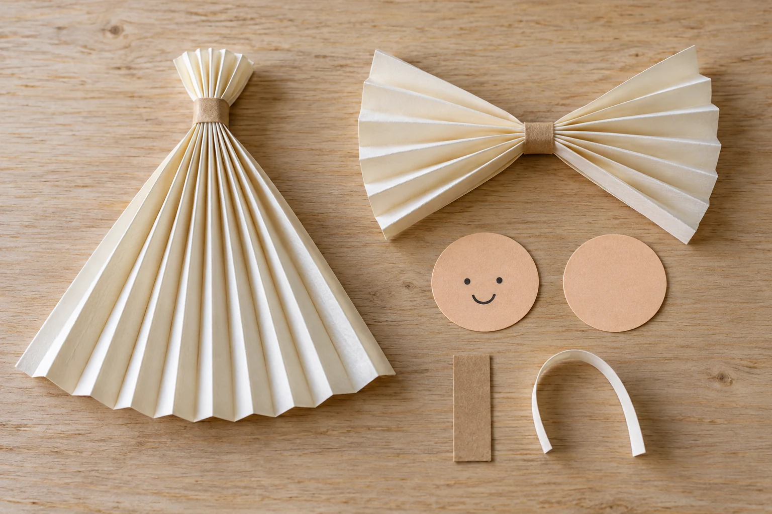 Pièces de papier plissé : robe en éventail, ailes ouvertes de chaque côté et deux disques de tête