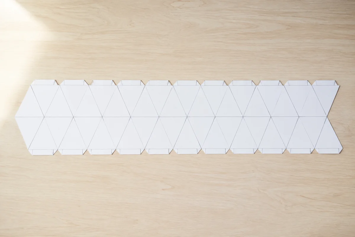 Étape 1 : réseau de triangles précis avec languettes, pour « Construire un kaléidocycle en papier à motifs géométriques ».