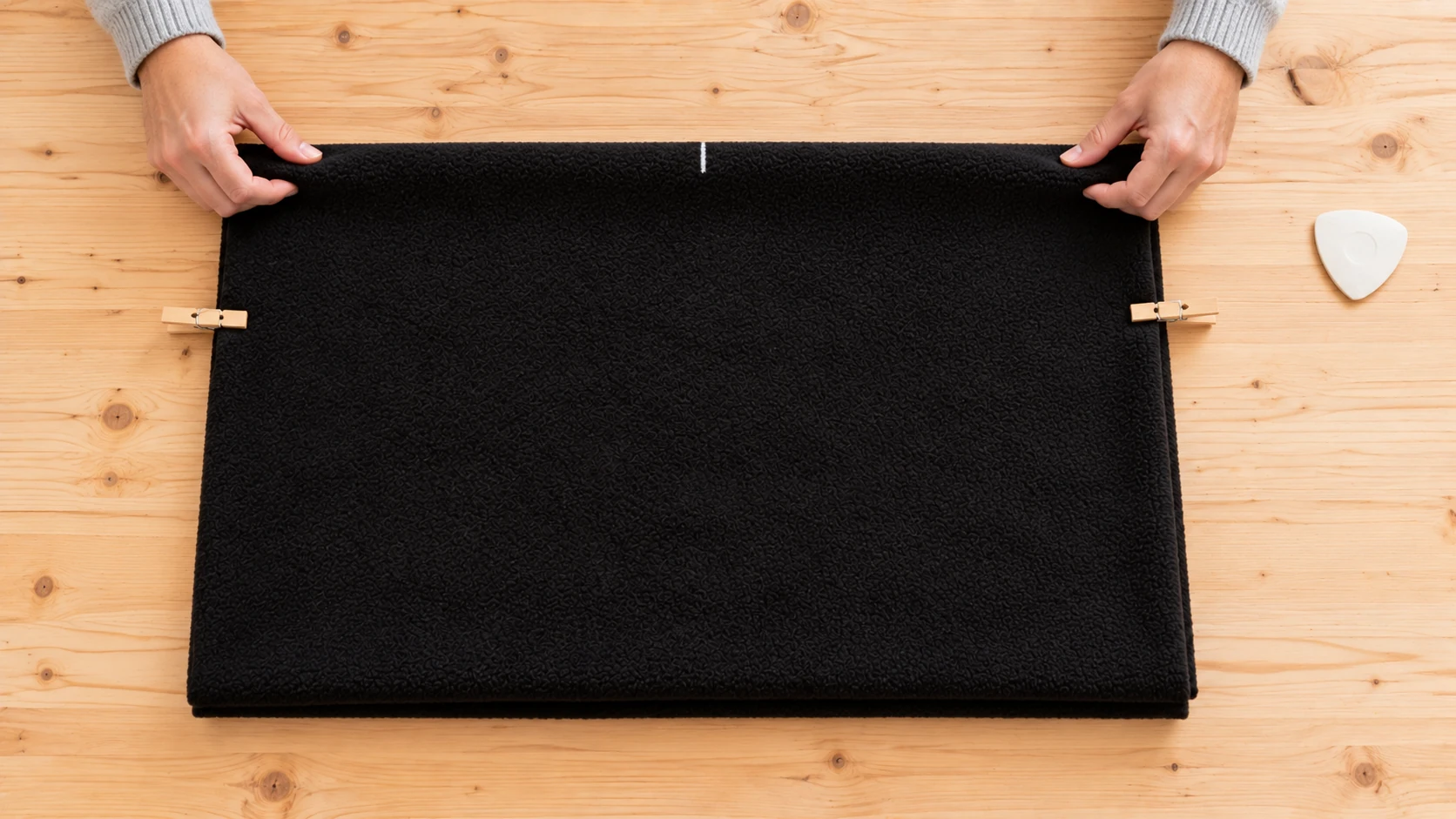 Rectangle noir plié en deux avec ligne d'épaules marquée en haut