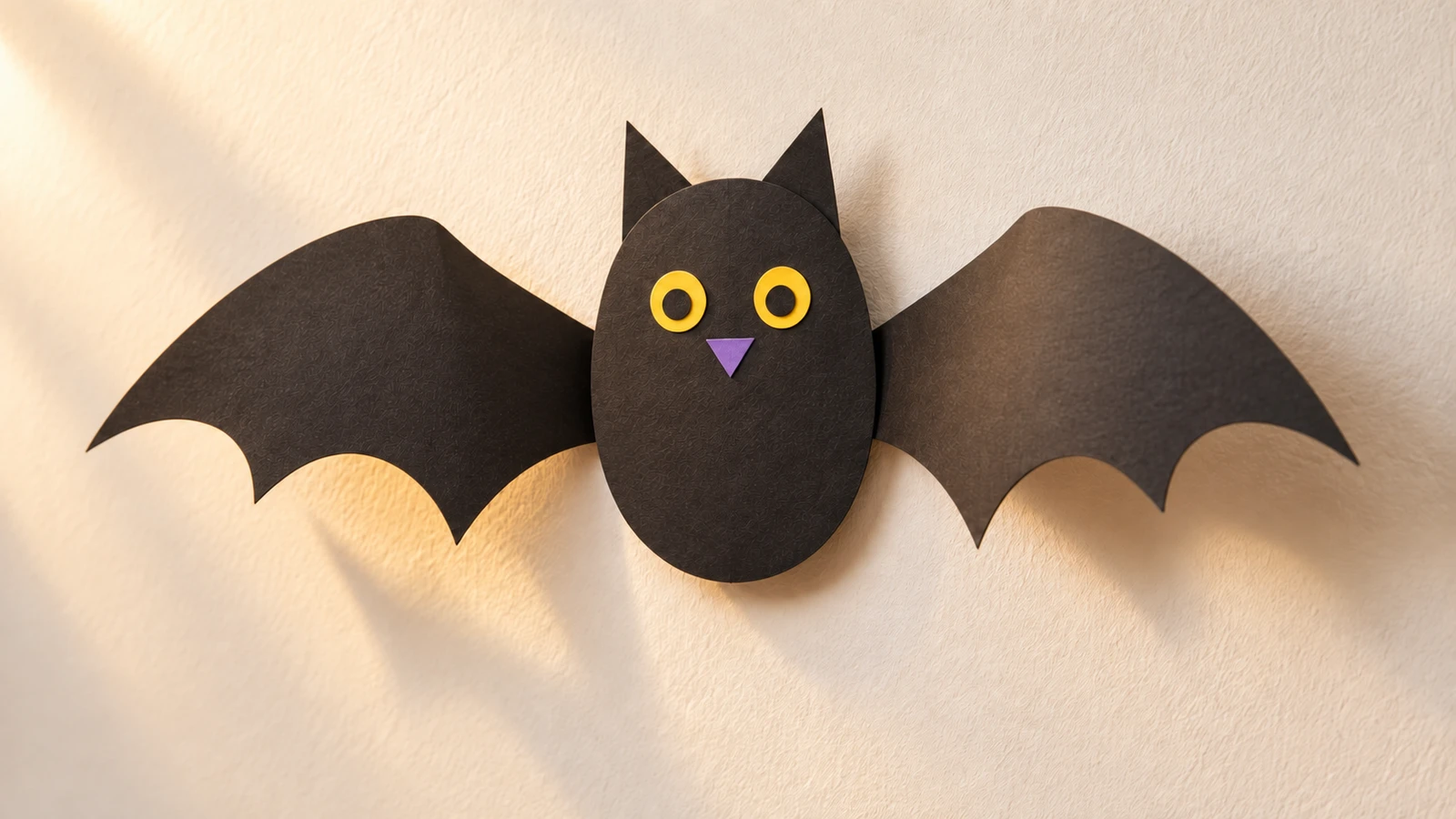 Chauve-souris de papier noir avec deux ailes latérales relevées par des plis