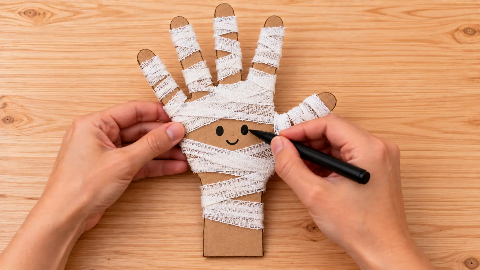 Ajouter un visage lisible pour fabriquer Main de momie Halloween en carton et gaze : une décoration à poser
