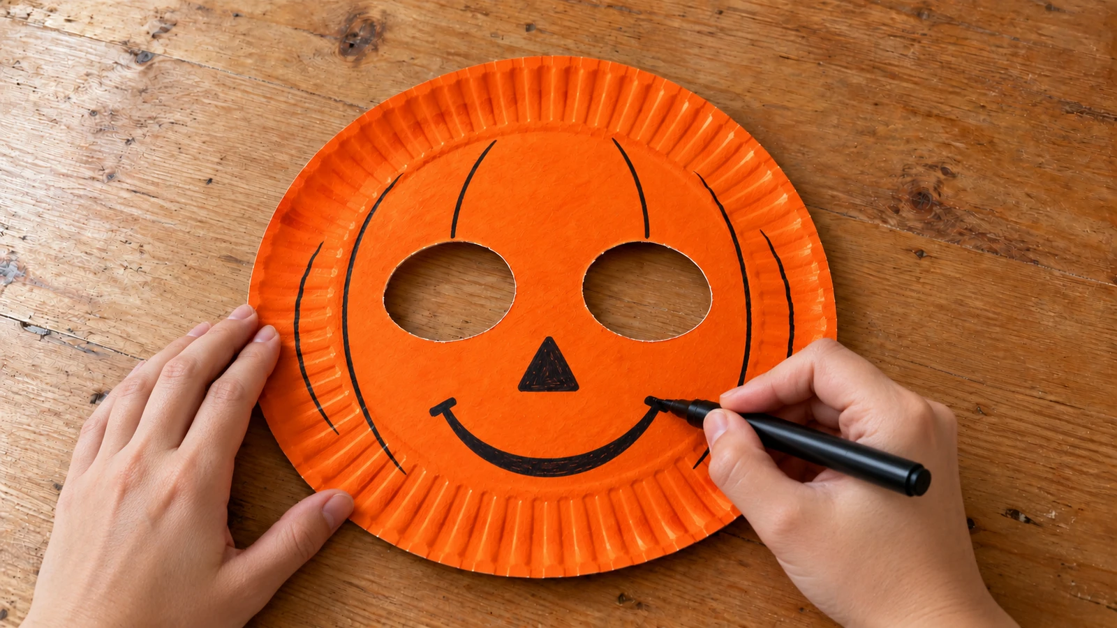 Nez triangulaire et sourire courbe dessinés sur le masque citrouille orange