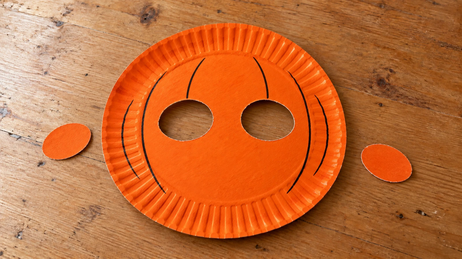 Masque orange avec deux ouvertures ovales et des courbes de relief dessinées