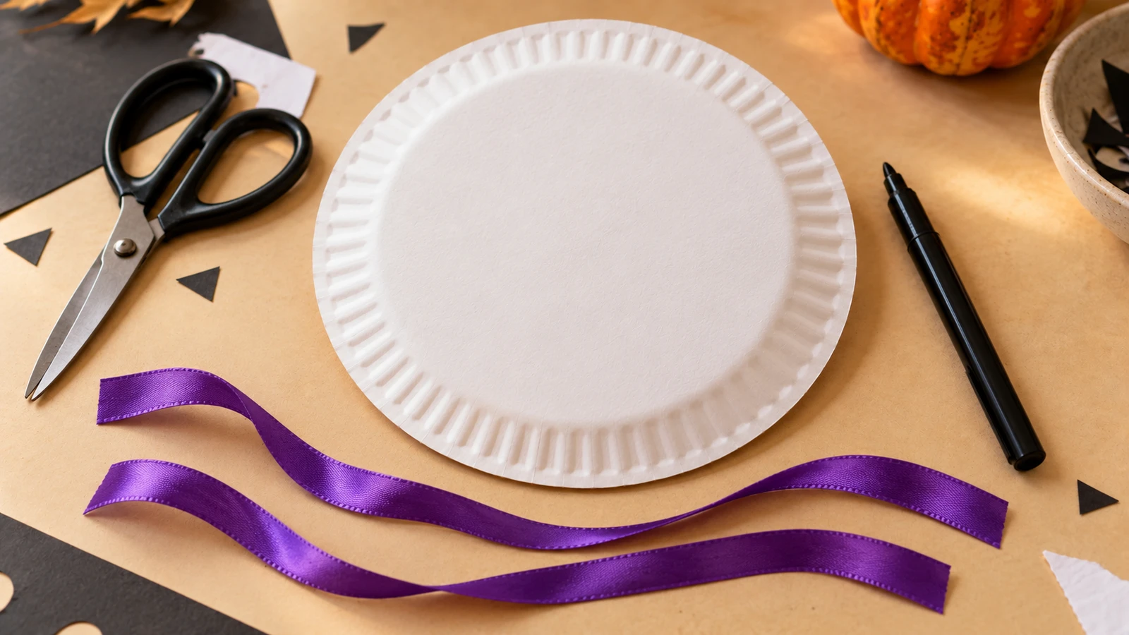 Assiette blanche, feutre noir, deux rubans violets et ciseaux pour le masque