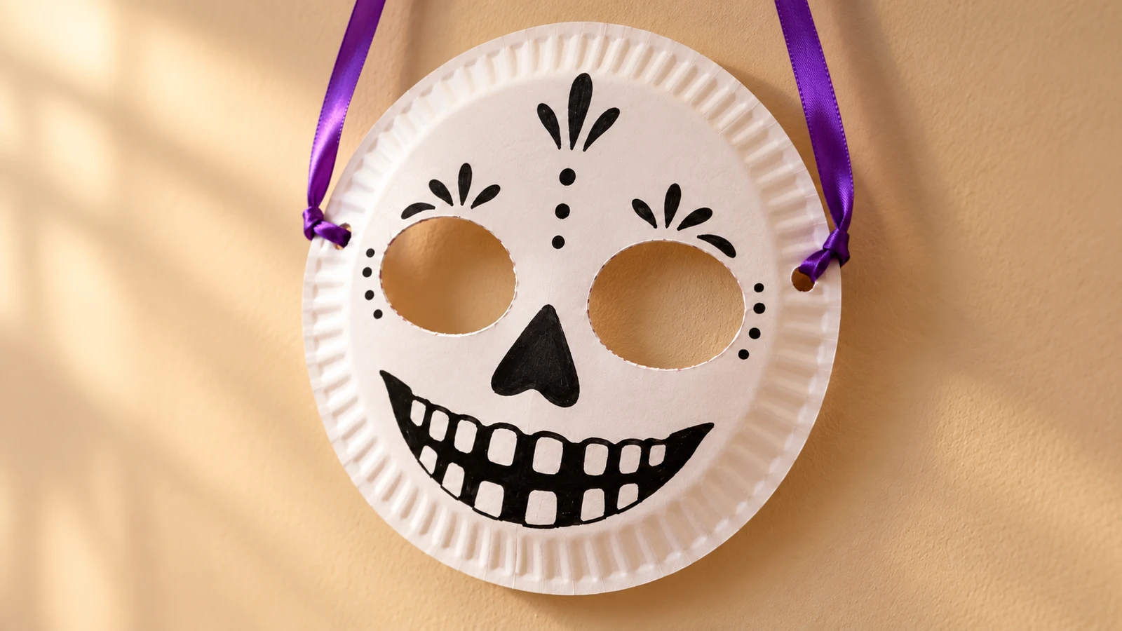 Masque squelette blanc en assiette cartonnée avec yeux ouverts et deux rubans violets