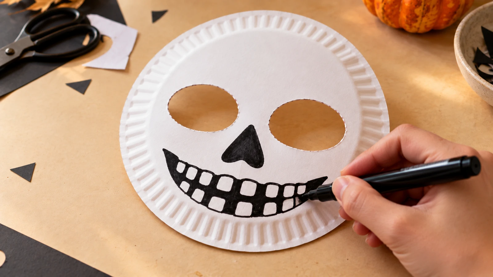 Nez triangulaire et bouche noire aux dents blanches dessinés sur le masque