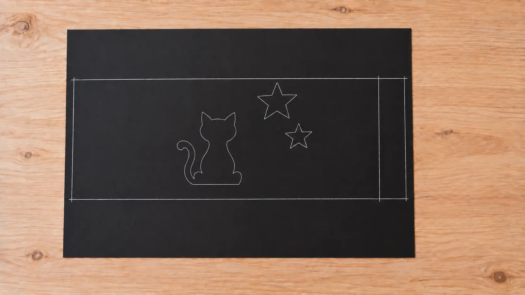 Contours d’un chat et de deux étoiles tracés sur la même bande noire