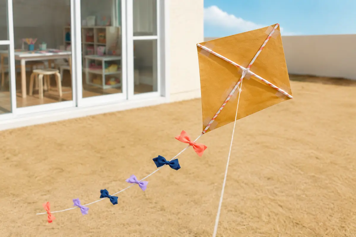 Petit cerf-volant losange en papier léger avec pailles en papier et longue queue