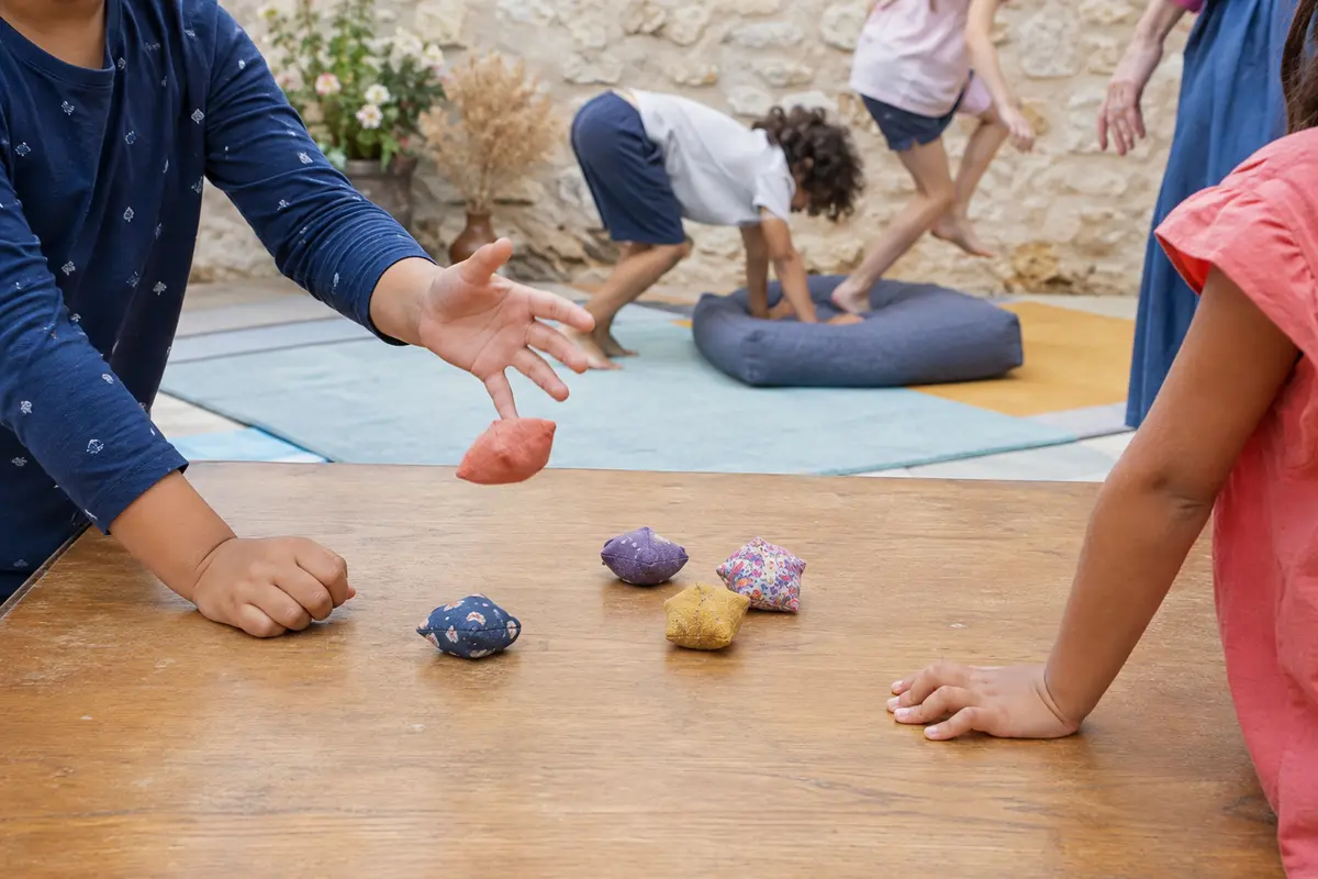 Enfants jouant à une version douce des osselets avec petits sachets de tissu